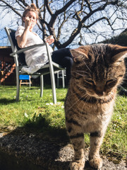 cat hanging in the garden with young woman