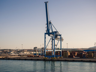 Obraz premium Shipping industrial trade port. Crane bridge and import export container at shipping port harbor.