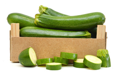 fresh zucchini's (Cucurbita pepo) in a wooden crate on a white background