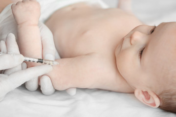 Obraz na płótnie Canvas Doctor vaccinating baby in clinic