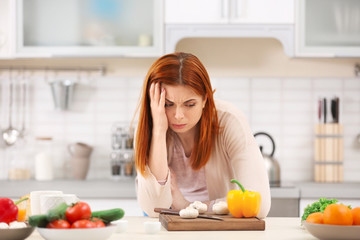 Tired housewife cooking in kitchen