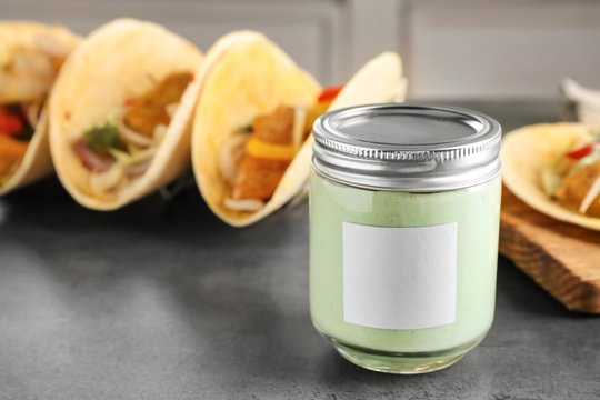 Tasty creamy sauce for fish taco in glass jar on kitchen table