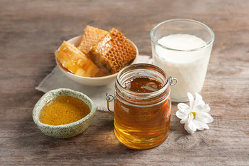 Beautiful composition with milk and honey on wooden background