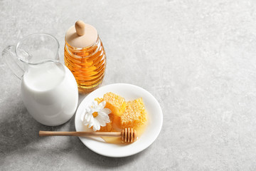 Beautiful composition with milk and honey on light background