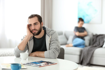 Young couple ignoring each other after having argument in living room
