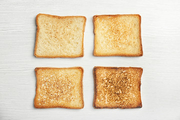 Toasted bread on light background, top view