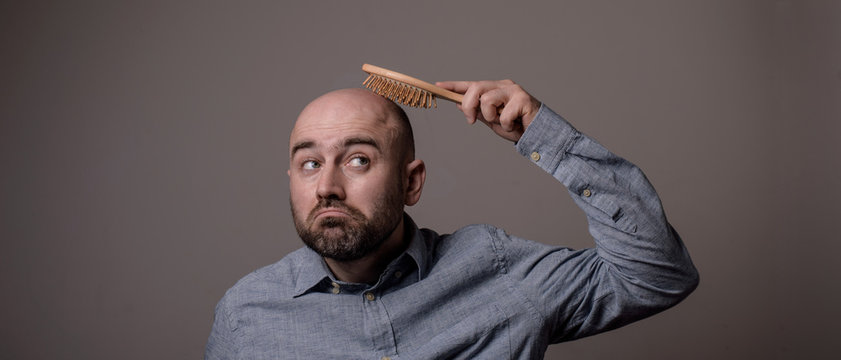 Confused Bald Man With Hair Brush