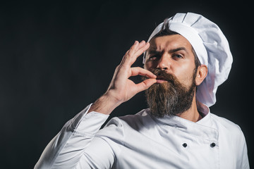 Serious bearded chef, cook or baker gesturing excellent. Male chef in white uniform with perfect...
