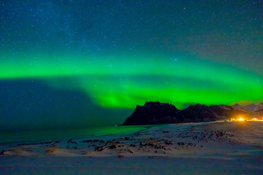 Beautiful picture of massive green vibrant Aurora Borealis, also know as Northern Lights in the night sky over Lofoten Islands © Fotos 593