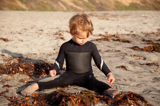 Boy Playing At Beach In Wetsuit