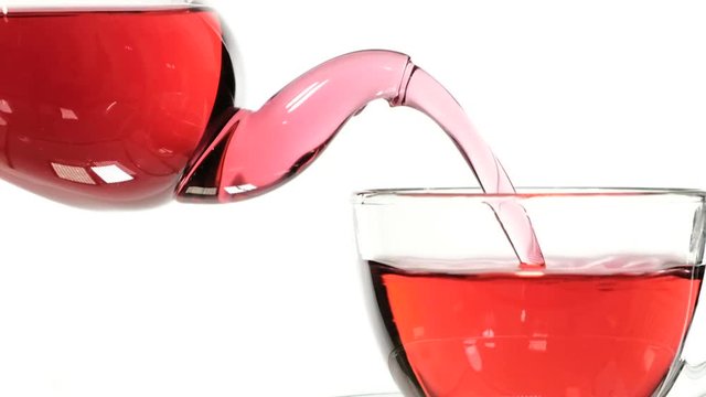 red rose tea in a glass teapot and a cup on a white background.