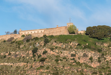 Fototapeta premium Montjuic fortress overlooking Barcelona harbor from the port
