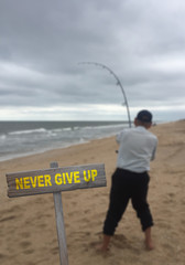 Never Give Up sign on beach background with struggling fisherman