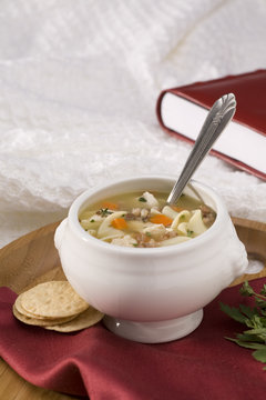 chicken noodle soup on tray with book