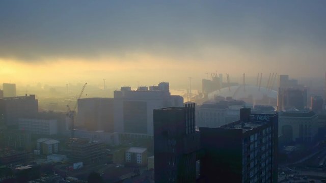 Drone shot of London O2 arena at sunrise on a foggy morning