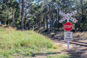 red, black and white Stop, Look For Trains, Railway Crossing warning signs at railway tracks in rural Australia