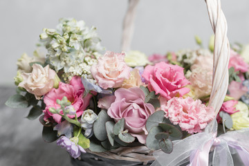 Beautiful flower composition a bouquet in a wicker basket. Floristry concept. Spring colors