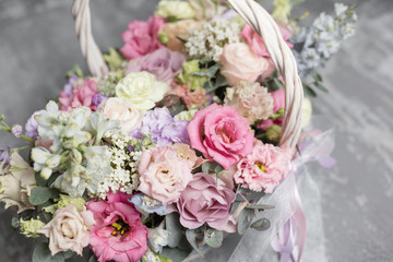 Beautiful flower composition a bouquet in a wicker basket. Floristry concept. Spring colors