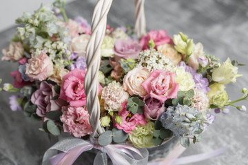 Beautiful flower composition a bouquet in a wicker basket. Floristry concept. Spring colors