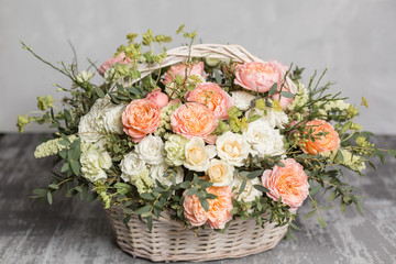 Beautiful flower composition a bouquet in a wicker basket. Floristry concept. Spring colors