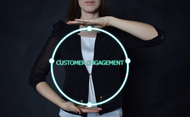 In the hands of a businessman, a neon circle with the inscription:CUSTOMER ENGAGEMENT