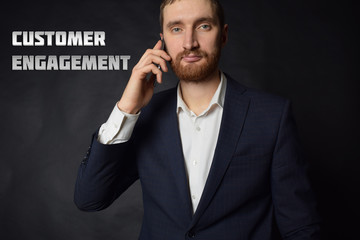 A businessman shows an inscription:CUSTOMER ENGAGEMENT