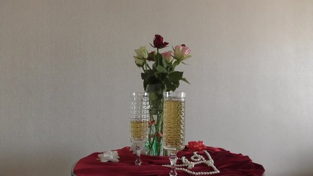 Still life of wedding wine glasses and a bouquet of roses