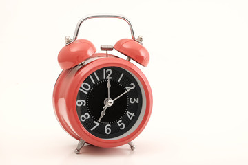 Red vintage alarm clock on white background.