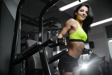 Fototapeta na wymiar brunette sexy athletic young girl working out in gym