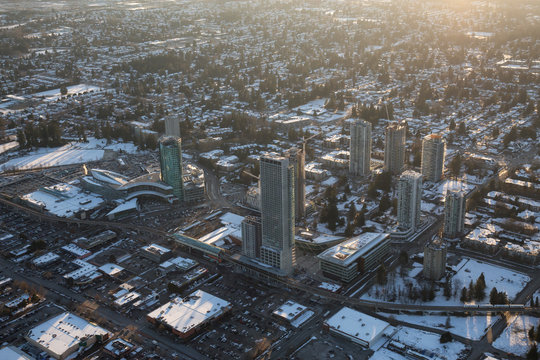Vancouver, British Columbia, Canada - February 22, 2018: Aerial view of Surrey Central Mall and Residential Buildings during a vibrant winter sunset.