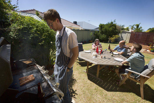 A Young Guy Cooking Food For An Aussie Barbecue.