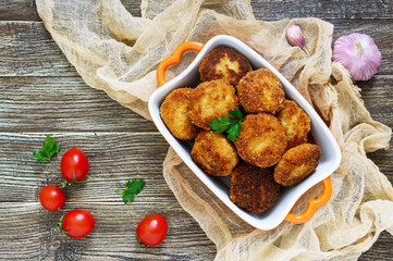 Cutlets. Fried cutlets in a ceramic bowl on a wooden table. Top view.