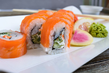 Philadelphia roll sushi with salmon, prawn, avocado, cream cheese  served on wooden background. Sushi menu. Japanese food. Sushi set.