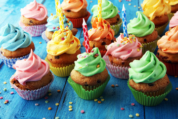 Tasty cupcakes on wooden background. Birthday cupcake in rainbow colors