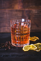 A glass with whiskey on a wooden background. - 200614873