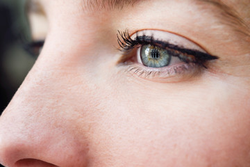 Fototapeta na wymiar Close-up shot of blue eye of young woman