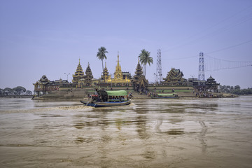 Passengers are transporting tourists across the river to pay homage to the temple.