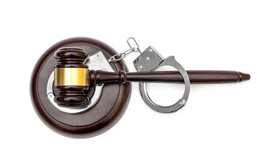 Gavel with stand and handcuffs on white background. Top view.