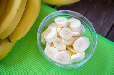 close up of fresh bananas and sliced banana in the bowl, top view.