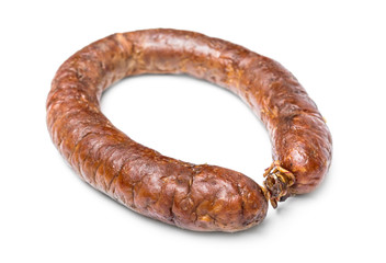 Ring of smoked sausage on white background.