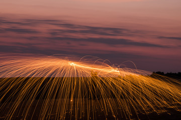 Fire spin wheel abstract effect at night in dessert
