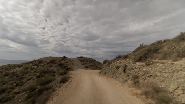 hyperlaspe pov driving on off road tracks in the puntas de calnegre natural park on the coast in murcia, spain