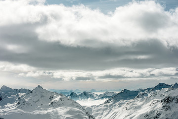 Fototapeta na wymiar High Alpine landscape. Snow-capped mountain peaks on the horizon