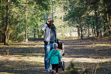 Dad and daughter watch the birds through binoculars. Birdwatchers in the spring forest.