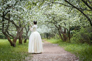 girl in a vintage white dress is back in the Apple-tree alley