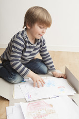 Niño (5 años) revisando en una carpeta sus dibujos.