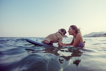 Girl with funny dog in the sea
