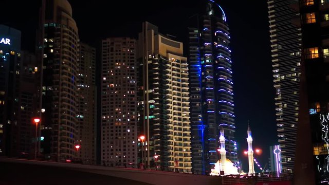 Night light street view in Dubai Marina. Modern building and Mosque