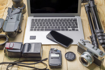 top view of work space photographer and travel concept with camera, drone,flash, computer laptop on wooden background