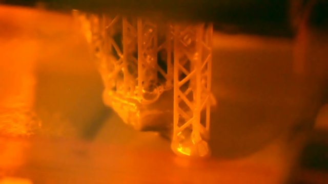 Stereolithography DPL SLA 3d printer create and liquid drips, platform slowly move with liquid close-up. Progressive modern additive technology 3D printing, create scaled model by UV polymerization